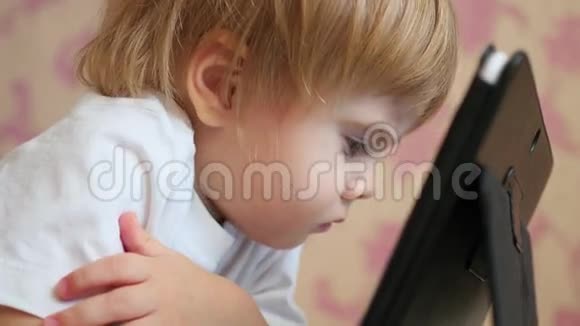 儿童在平板电脑上看卡通特写视频的预览图