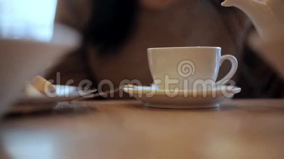 女人把水壶里的热水倒进杯子里视频的预览图