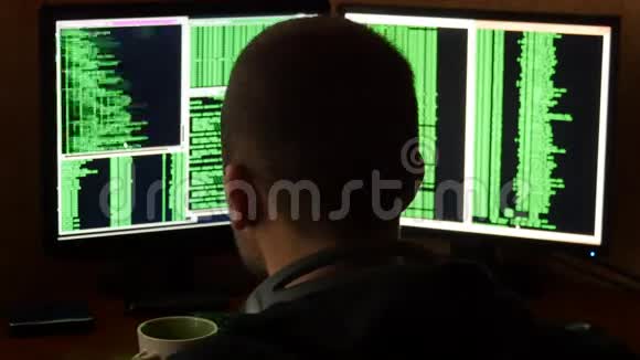 黑客破坏代码从你桌子上的杯子里喝酒黑客从黑暗中侵入网络系统视频的预览图