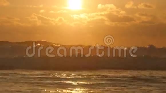日落时美丽的金色海浪橙色的日出反射在海水上强烈的潮汐和波浪溅在上面视频的预览图