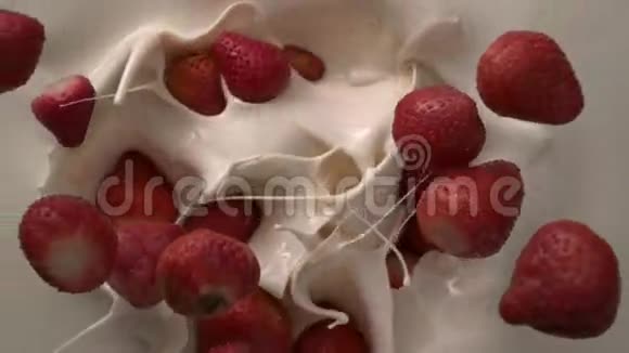 带草莓的按摩浴缸在白色的奶油液体桌面上缓缓落下视频的预览图