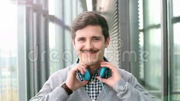 英俊的年轻人戴上耳机听音乐的肖像视频的预览图
