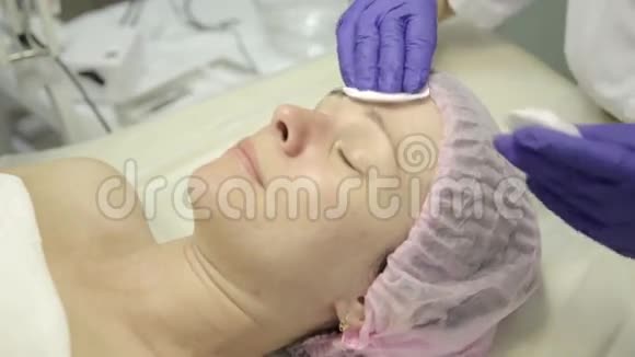 接受水疗治疗的女人用棉签清洗妇女面部视频的预览图