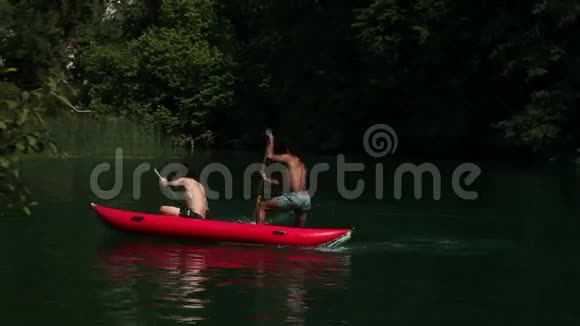 两个男性朋友骑着独木舟用桨把她们的女性朋友溅了起来视频的预览图