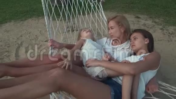 快乐的母亲和女儿在吊床上摇摆慢动作股票录像视频的预览图