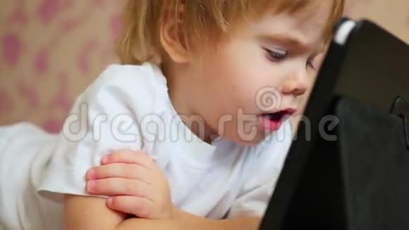 儿童在平板电脑上看卡通特写视频的预览图