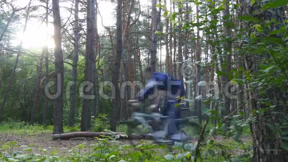 两个骑自行车的人在森林里骑自行车山地自行车手在一片绿色的树林里经过摄像机现役男子视频的预览图