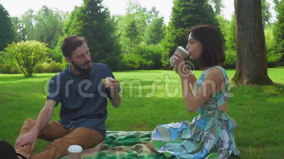 那个带着女孩的家伙在野餐时吃沙拉三明治然后用咖啡洗掉相互沟通视频的预览图