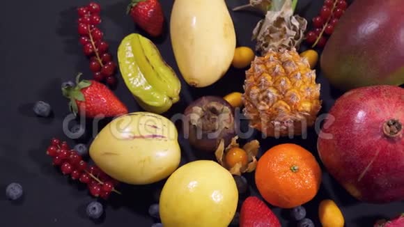 不同种类的水果分布在黑色背景的桌子上视频的预览图