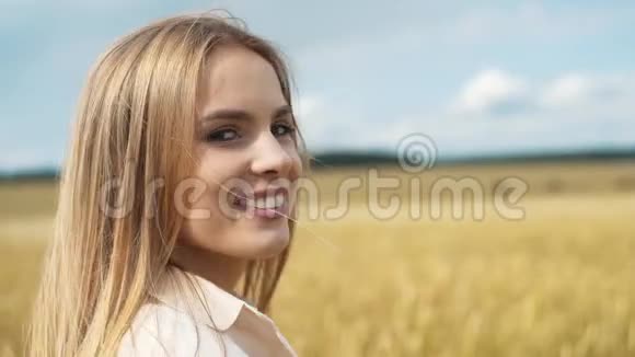 阳光明媚的夏天一位美丽微笑的年轻女子的肖像视频的预览图