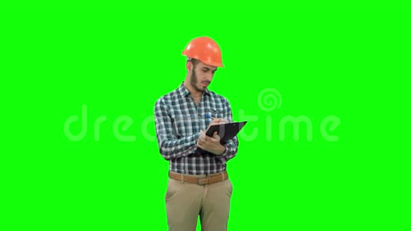 年轻工程师在头盔检查施工现场的绿色屏幕铬键视频的预览图