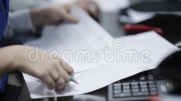 办公桌上的办公室工作人员处理文件和电脑视频的预览图