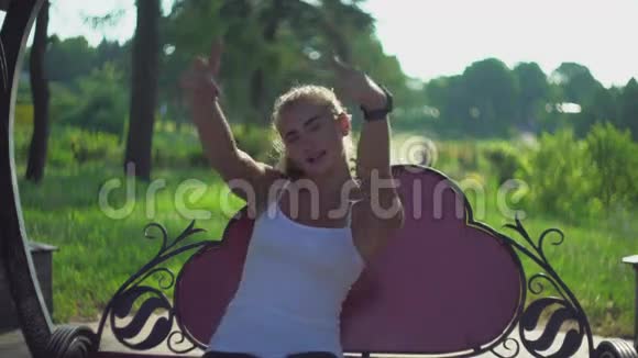 年轻女孩用手在长凳上跳舞笑了起来视频的预览图