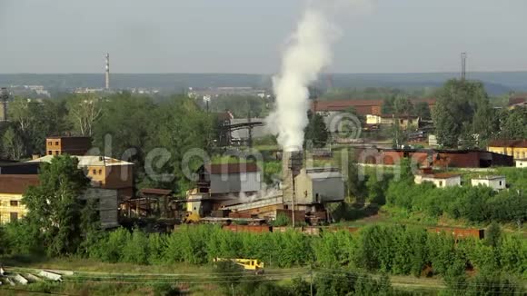 阿拉帕耶夫斯克的绿树和自然中工业植物烟雾的管道视频的预览图