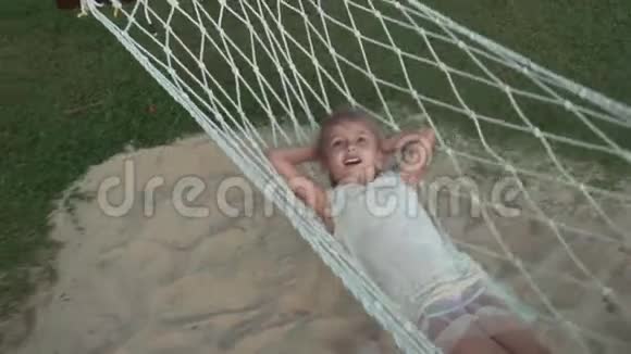 快乐的小女孩在吊床上摆动慢动作股票录像视频的预览图