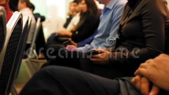 坐在主课或论坛的观众中的人群人们手里拿着小玩意关门视频的预览图