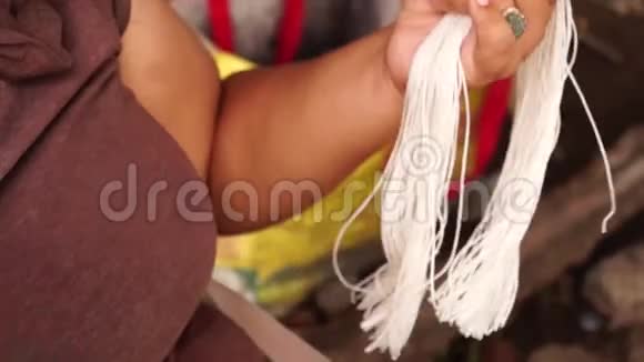 这位妇女赤手空拳用棉线在街边做烛芯视频的预览图