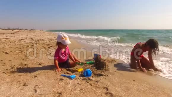 沙滩上两座儿童建筑沙堡视频的预览图