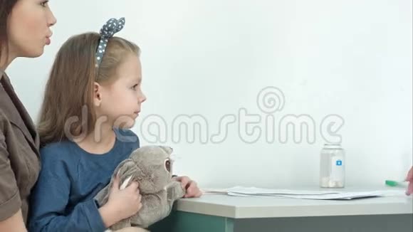 男儿科医生检查小女孩头部发热视频的预览图