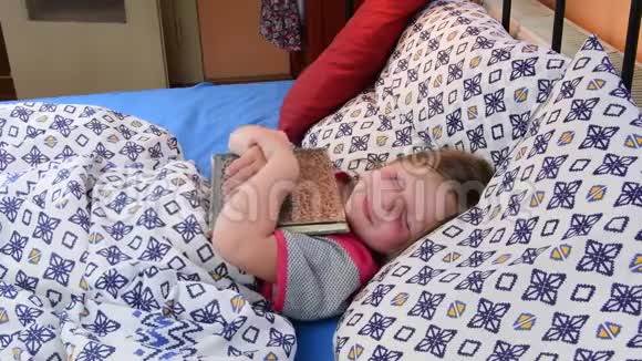 在床上的小女孩女孩子试着用父亲的日记睡着了床上有本旧书的小女孩家庭概念视频的预览图
