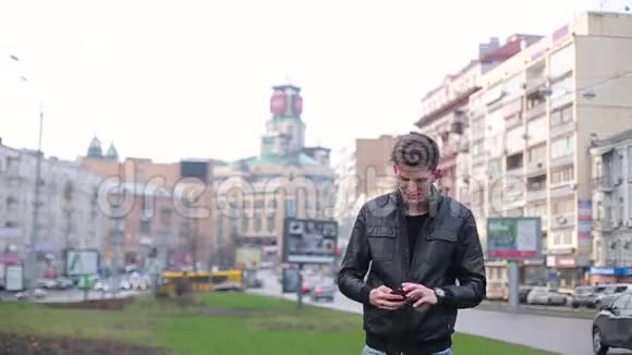高个子男人用智能手机拍城市照片视频的预览图