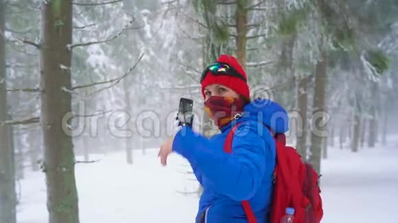 旅游女孩走在一个冬天白雪覆盖的针叶林在山上并在一个自然的照片视频的预览图