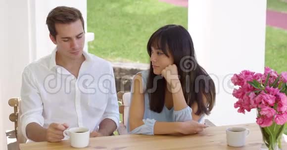 快乐的年轻情侣坐在桌旁视频的预览图