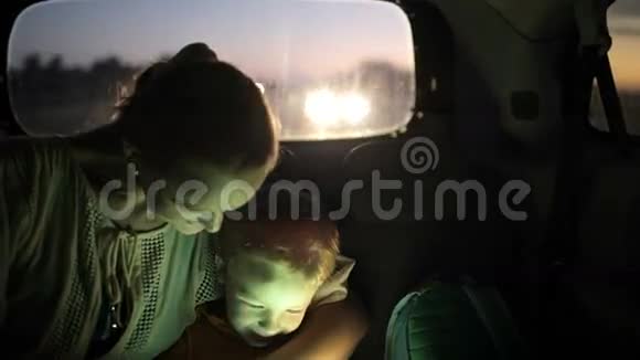 妈妈和儿子晚上在车里用触摸板视频的预览图