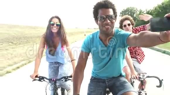 三个年轻人骑自行车慢动作带着手机自拍分级视频的预览图