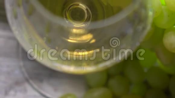 白色酒杯和一串绿色葡萄俯视图酒庄或酿酒理念4K关闭视频视频的预览图