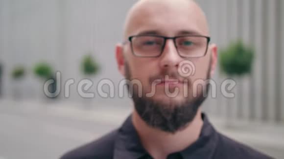 城市中戴眼镜胡子男的特写镜头视频的预览图