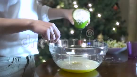 女人正在往一个玻璃碗里加入鸡蛋混合物视频的预览图