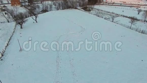 带着两个孩子拉雪橇的男人山村鸟瞰图视频的预览图