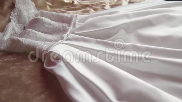 新娘漂亮的白色婚纱躺在一张大床上视频的预览图