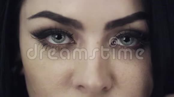美丽的女性脸嘴唇大可爱的蓝色眼睛和长长的黑发视频的预览图