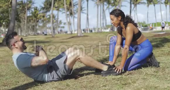 女人帮助男人在公园锻炼视频的预览图