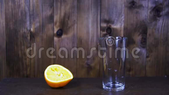 橙汁在木制背景下被倒入玻璃杯中慢动作视频的预览图