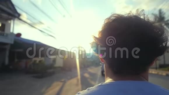 摩托车手驾驶摩托车在柏油路上行驶在美丽的日落时分在热带岛屿上慢动作视频的预览图