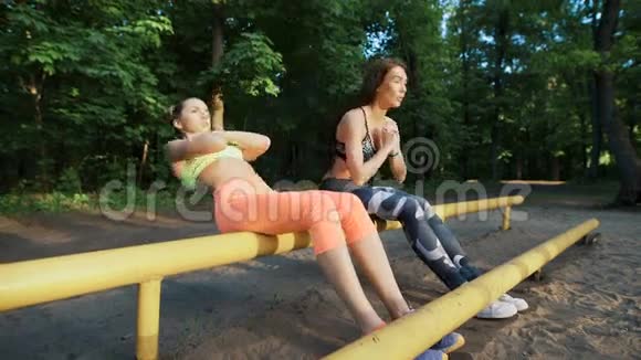 体育界人士克罗斯菲特两个苗条的女孩在操场上的公园里做运动视频的预览图