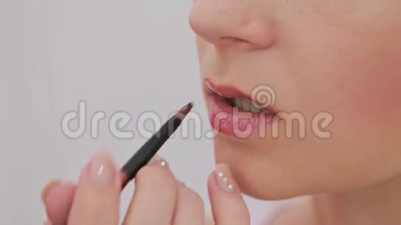 特写镜头专业化妆师在唇部涂唇膏视频的预览图