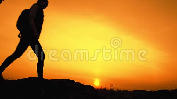 年轻的快乐旅行者在夏日日落的岩石小径上背着背包徒步旅行家庭旅行和冒险概念视频的预览图