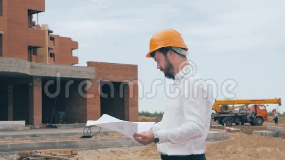 在施工现场绘制图纸的工程师戴着安全帽的建筑大师视频的预览图
