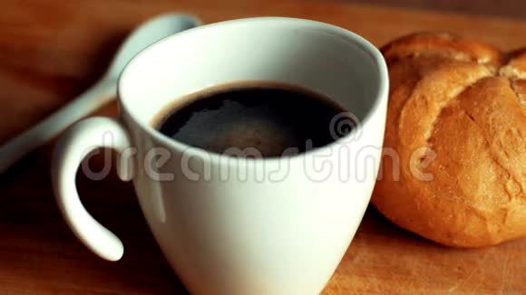 热咖啡和牛奶倒在木桌上的白色杯子里女人用手倒咖啡和牛奶关闭4k视频的预览图