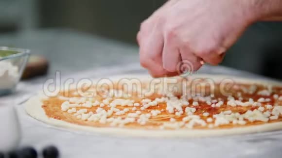 餐厅厨房厨师在披萨上放奶酪视频的预览图