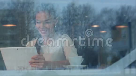 美丽的年轻女子使用平板电脑在咖啡馆打视频电话视频的预览图