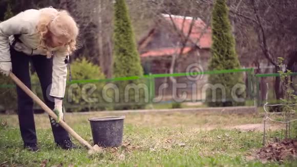 女人用铲子在花园里挖泥土视频的预览图