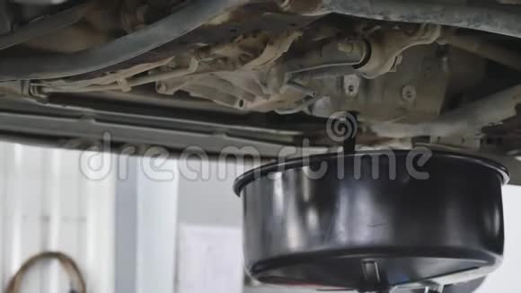 汽车修理工在汽车换油期间从汽车上抽出机油视频的预览图