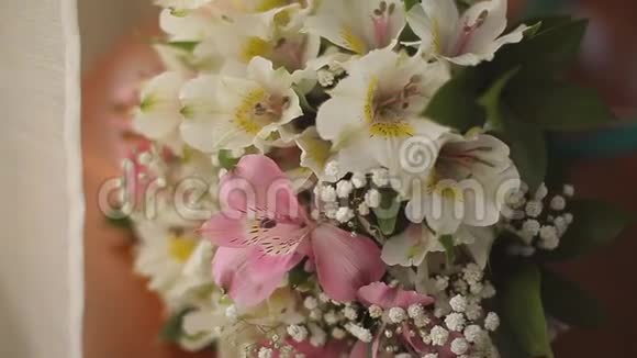 新娘花束背景上的结婚戒指视频的预览图