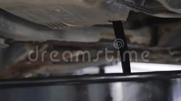 汽车修理工在汽车换油期间从汽车上抽出机油视频的预览图