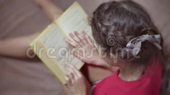 少女读书坐在沙发上女孩在沙发上看书女孩室内教育视频的预览图